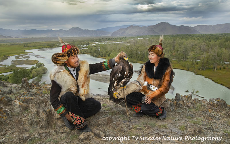 Two Mongolian Eagle Hunters on Cliff above RIver Valley